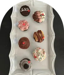Assorted cupcakes on a white tray.
