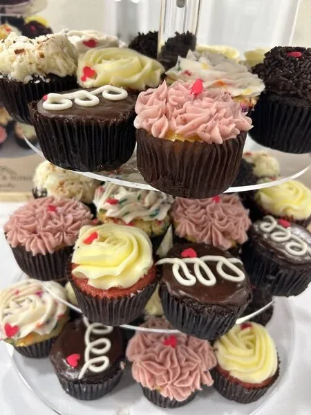 Tray of assorted custom cupcakes with frosting swirls and toppings