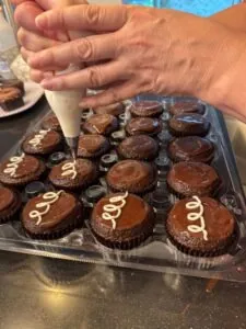 Assorted custom cupcakes with piped frosting arranged in a tray