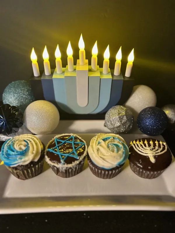 Birthday cupcakes with lit candles arranged on a table for celebration